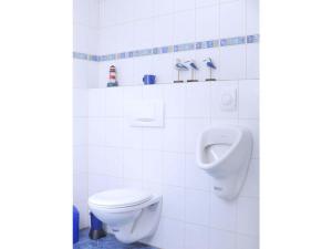 ein weißes Bad mit WC und Urinal in der Unterkunft Holiday apartment Haus Kirsch in Hilders