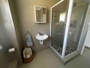 a bathroom with a shower and a sink at Modern 2 bedroom apartment close to shops & beach in Gordonʼs Bay +6 photos