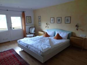 a bedroom with a bed with white sheets and orange pillows at Fantastic apartment in Bad Hindelang in Bad Hindelang