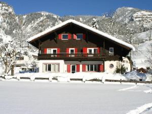 a house covered in snow in front of a mountain at Fantastic apartment in Bad Hindelang in Bad Hindelang