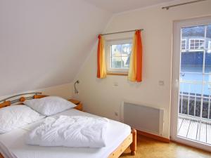 a bedroom with a bed and a window at Semi-detached house Strandhaus I, Trassenheide in Trassenheide