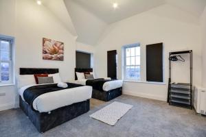ウィガンにある3 Bed Apartment in Wiganのベッドルーム(ベッド2台、テレビ付)