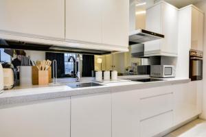 a white kitchen with white cabinets and appliances at 3 Bed Apartment in Wigan in Wigan