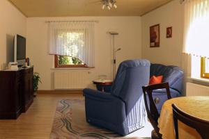 a living room with a blue chair and a television at Apartment view of fortress in Pirna in Pirna