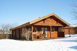 a large wooden cabin in the snow with snow at Holiday homes Lauterd rfle Hayingen in Hayingen