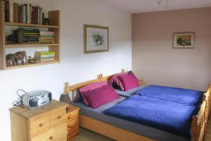 - une chambre avec un lit doté de draps bleus et d'oreillers roses dans l'établissement Holiday home in Losheim am See, à Wahlen