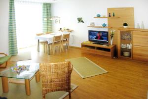 un soggiorno con TV e una sala da pranzo di Apartment in Cuxhaven with community pool a Cuxhaven