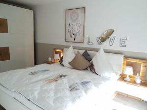 - une chambre avec un lit doté de draps et d'oreillers blancs dans l'établissement Holiday apartment Saartal - SENTA, 