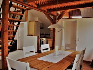 a dining room with a wooden table and white chairs at 1 in the Maaßen country house in Stakendorf