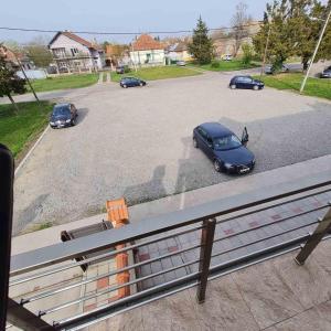 a parking lot with cars parked in a parking lot at Apartman Dalmacija in Ečka