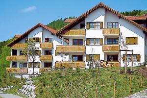 un gran edificio blanco con balcones de madera en una colina en Alpine residence in Weitnau, en Weitnau