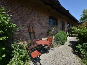 a table and chairs next to a brick building at Rustic style Apartment in Buschenhagen with Garden in Buschenhagen