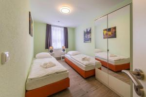 Zimmer mit 2 Betten und einem Spiegel in der Unterkunft Apartment Schlossblick Wernigerode in Wernigerode