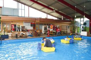 een zwembad met mensen in stoelen in het water bij Apartment in Burhave with a shared pool in Burhave