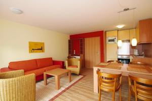 ein Wohnzimmer und eine Küche mit einem Sofa und einem Tisch in der Unterkunft Apartment in Burhave with a shared pool in Burhave