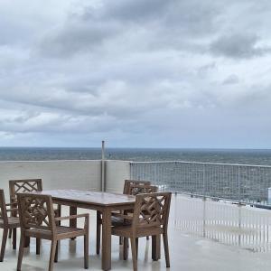 a table and chairs on a balcony with the ocean at Kings Beachside Escape spacious apartment centrally located in Caloundra