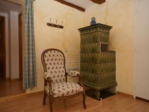 una silla y un armario en una habitación en An apartment in a 17th century wine grower s house, en Riquewihr