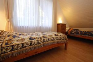 ein Schlafzimmer mit einem Bett und einem Fenster mit einem Vorhang in der Unterkunft Apartment house Katharina Westerland in Westerland
