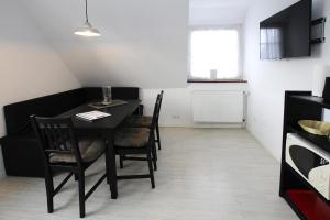 a dining room with a black table and chairs at Apartment in Westerland in Westerland (Sylt)