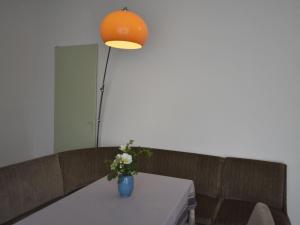 een vaas met bloemen op een tafel met een lamp bij Modern Bungalow in Blowatz near Sea in Blowatz