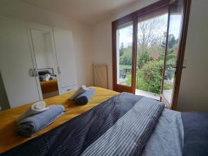 1 dormitorio con 1 cama con toallas en L'écureuil parisien Maison de charme avec jardin proche Paris, en Cormeilles-en-Parisis