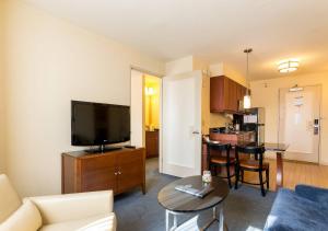 een woonkamer met een bank en een flatscreen-tv bij Beautiful & Cozy 1BR in NYC! in New York