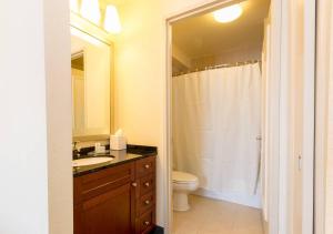 een badkamer met een wastafel, een toilet en een spiegel bij Beautiful & Cozy 1BR in NYC! in New York