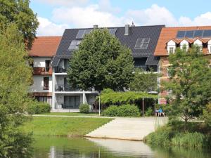 a building with solar panels on it next to a river at Apartment in L bben near the water in Lübben