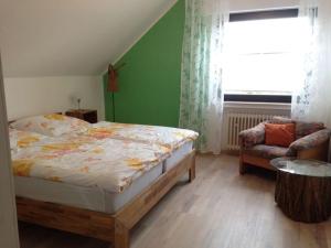 een slaapkamer met een bed, een raam en een stoel bij Holiday apartment Xantener Aue in Xanten