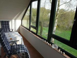 een afgeschermde veranda met 2 stoelen en 2 ramen bij Holiday apartment Xantener Aue in Xanten