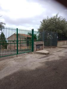 a green metal fence with a ramp behind it at House Italia Holiday in Trabia