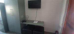 Habitación con escritorio y TV en la pared. en 22 on Port Natal Hartenbos, en Hartenbos