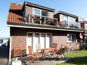 une terrasse avec une table et des chaises dans une maison dans l'établissement A in Haus Seewind Comfortable Vacation Home, à Wittdün