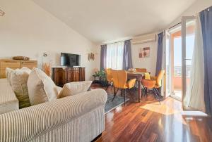 ein Wohnzimmer mit einem Sofa und einem Tisch mit Stühlen in der Unterkunft Vesna in Novigrad Istria