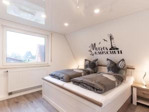 ein Schlafzimmer mit einem Bett mit einem Schild an der Wand in der Unterkunft Casa del Maiwaldo in Spieka-Neufeld