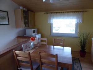 a kitchen with a dining room table and a microwave at Lovely Holiday Home in Bastorf Germany with Garden in Zweedorf