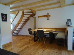 a dining room with a table and chairs and a staircase at Holiday apartment Beerewieble in Unterkirnach