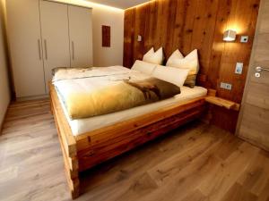 ein Schlafzimmer mit einem Bett mit einer Holzwand in der Unterkunft Holiday apartment Holzwieb in Unterkirnach