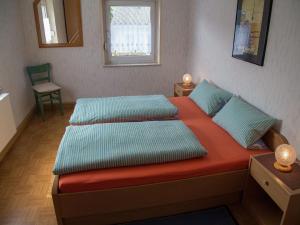 1 dormitorio con 2 camas, silla y ventana en Spacious Holiday Home in Ulmen near the centre, en Ulmen