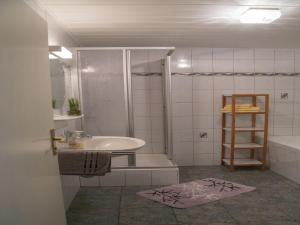 y baño con ducha, lavabo y bañera. en Spacious Holiday Home in Ulmen near the centre, en Ulmen