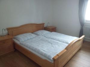 ein Schlafzimmer mit einem Holzbett mit zwei Nachttischen und einem Fenster in der Unterkunft Holiday apartment Rosi Denz 