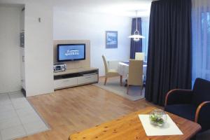 un soggiorno con TV e tavolo da pranzo di Apartment in Cuxhaven with community pool a Cuxhaven