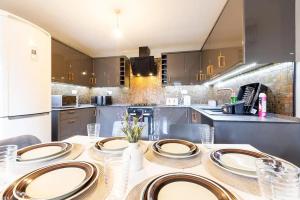 a kitchen with a table with plates on it at Large 5-Bed House in Leeds Fits 10 Free Parking in Leeds