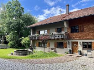 ein Backsteinhaus mit einer Veranda und einer Terrasse in der Unterkunft Apartment in the Waxenegg country house in Sulzberg