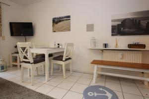 a living room with a table and chairs and a tv at Apartment Garding in Garding