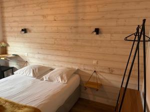 Cama en habitación con pared de madera en Hôtel Bellevue en Mimizan-Plage