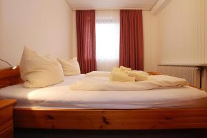 - un lit avec des draps et des oreillers blancs et une fenêtre dans l'établissement Apartment in Westerland, à Westerland