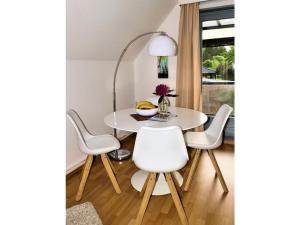 a dining room with a white table and chairs at Holiday apartment Green House in Aumühle +8 photos