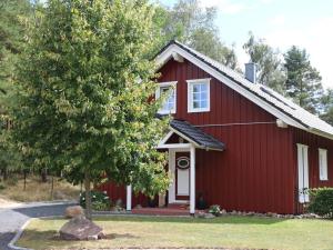 a red house with a tree in front of it at Holiday home Sweden house in Kaarßen