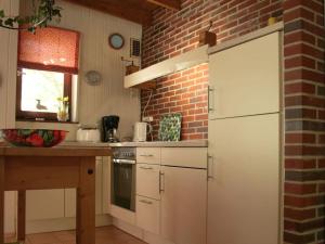 uma cozinha com armários brancos e uma parede de tijolos em Holiday house house by the lake em Langwedel